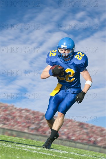 Caucasian football player running with ball