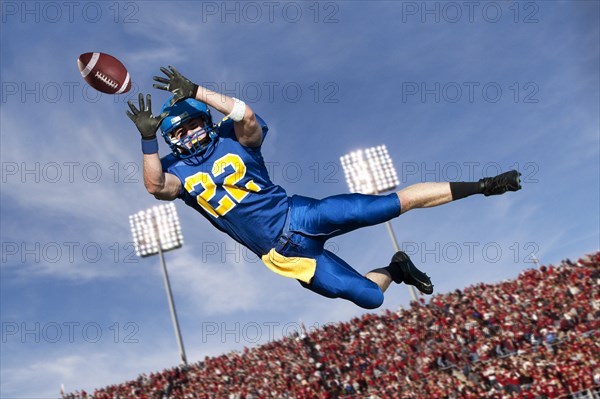 Caucasian football player catching ball