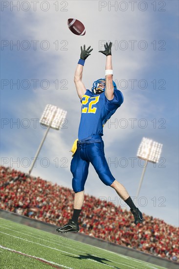 Caucasian football player catching ball