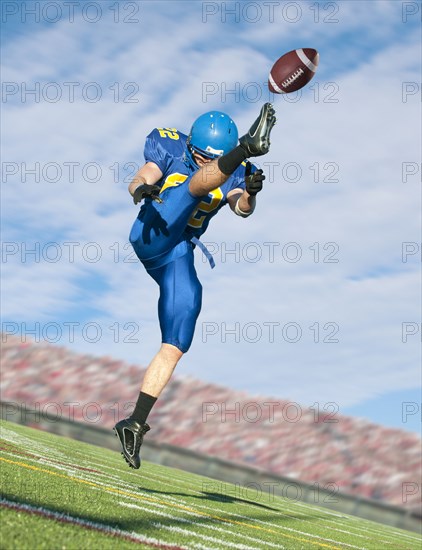 Caucasian football player kicking ball