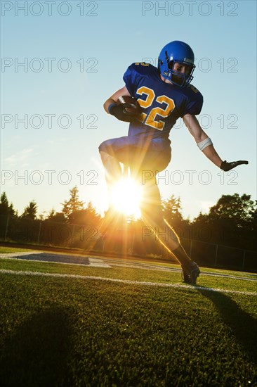 Caucasian football player running with ball