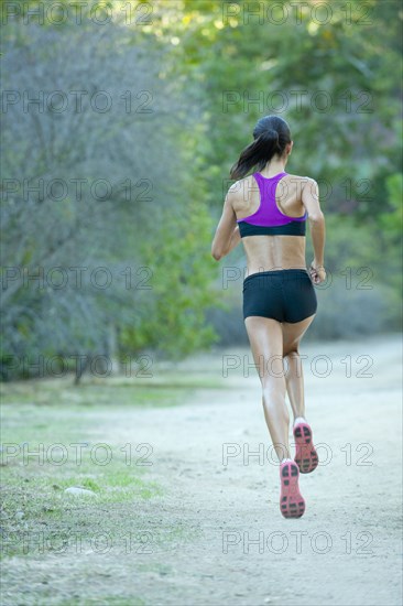 Hispanic woman running on remote path