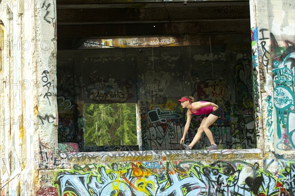 Caucasian woman stretching in abandoned loading dock