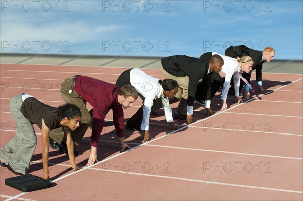 Business people crouching at starting line on track