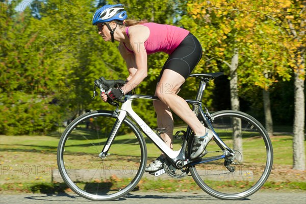 Caucasian woman riding bicycle in park