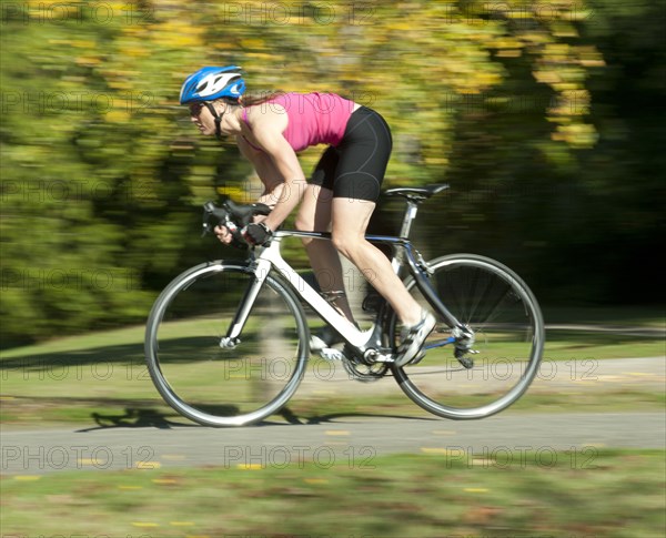 Caucasian woman riding bicycle in park