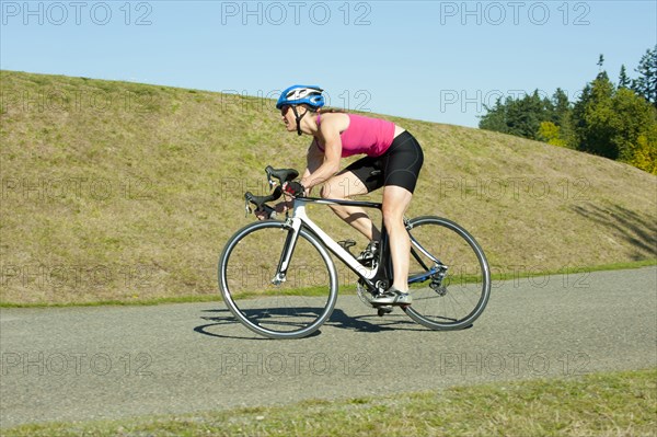 Caucasian woman riding bicycle in park