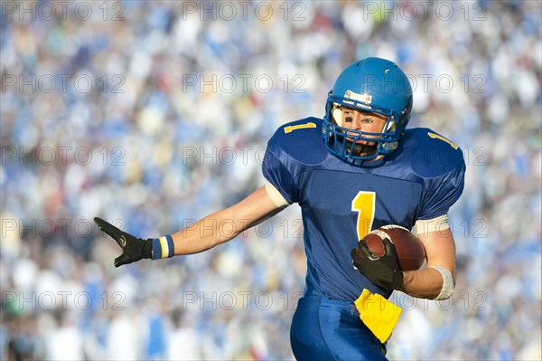 Caucasian football player running with football