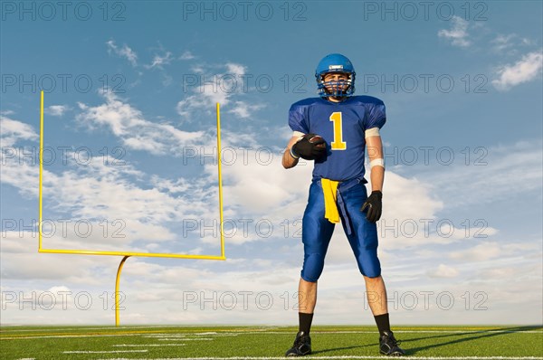 Caucasian football player standing with football
