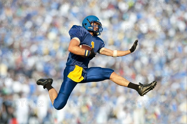 Caucasian football player running with football