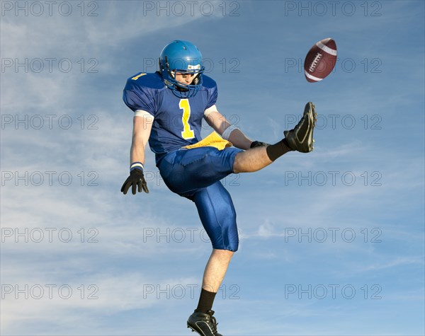 Caucasian football player kicking football