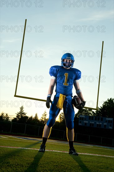 Caucasian football player standing with football