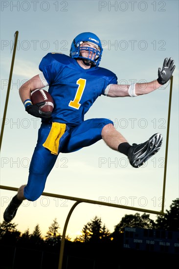 Caucasian football player running with football