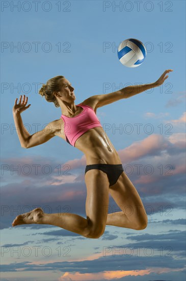 Caucasian volleyball player hitting volleyball