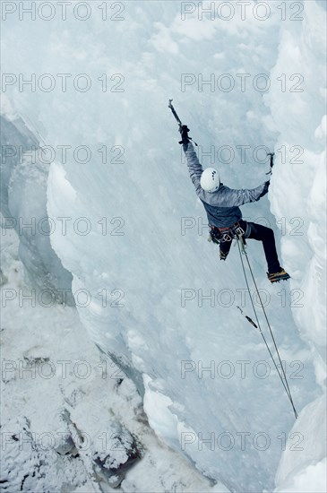 Caucasian man climbing ice