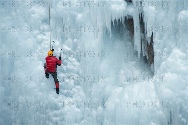 Caucasian man climbing ice wall