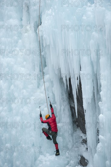 Caucasian man climbing ice wall