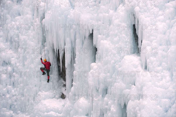 Caucasian man climbing ice wall