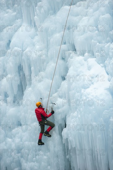 Caucasian man climbing ice wall