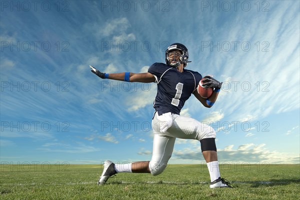 African American football player poised on field