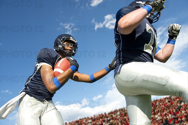 Football players passing ball