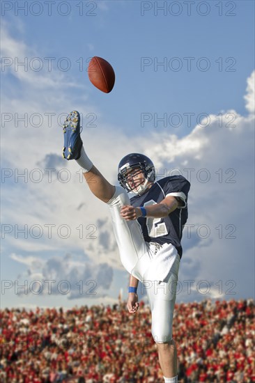 Caucasian football player kicking ball