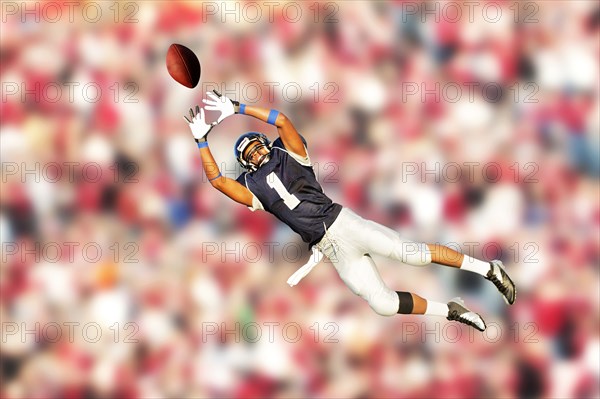 African American football player catching ball