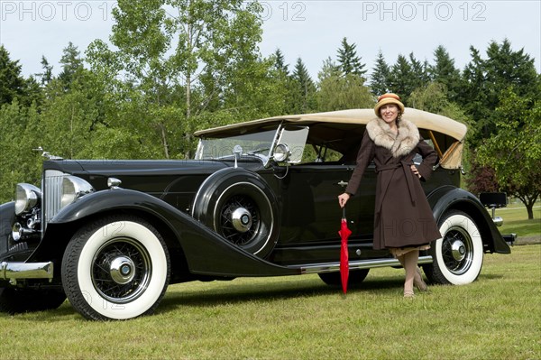 Caucasian woman by vintage car