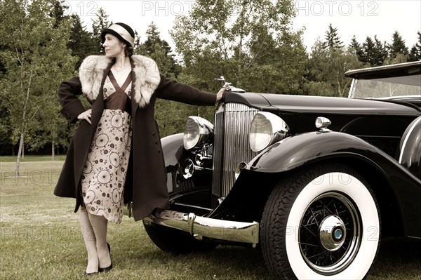 Caucasian woman by vintage car