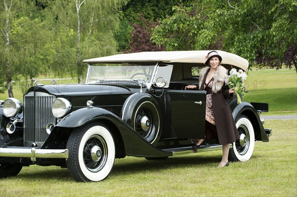 Caucasian woman by vintage car