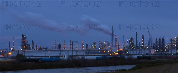 Factory near lake illuminated at night
