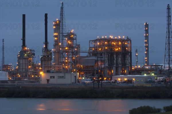 Factory near lake illuminated at night