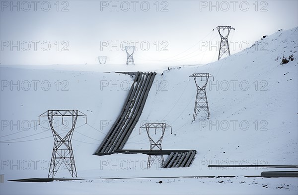 Power lines in snowy arctic landscape