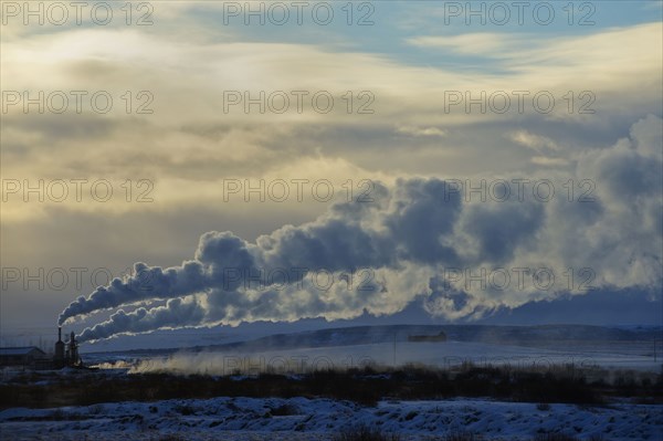 Distant power plant in arctic landscape