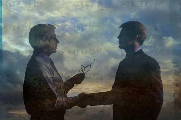 Double exposure of businessmen in clouds