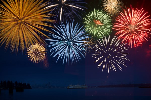 Fireworks exploding over cruise ship in bay