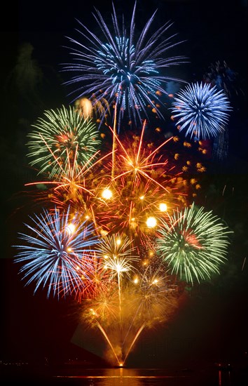 Fireworks exploding over cruise ship in harbor