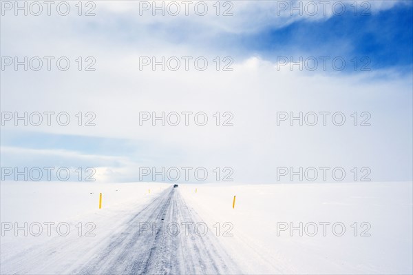 Tire tracks on rural road in snowy landscape