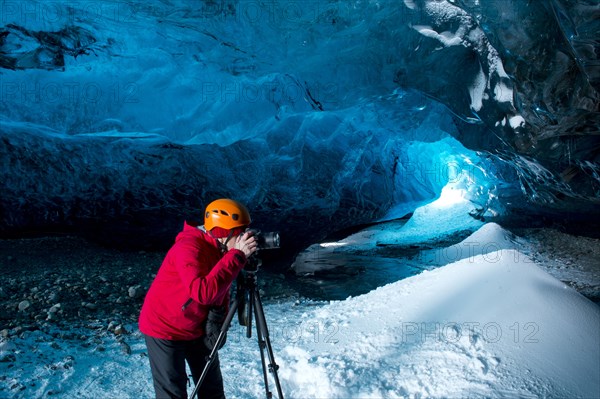 Photographer taking photograph in ice cave