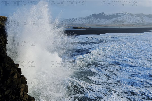 Waves splashing on rocky cliffs on beach