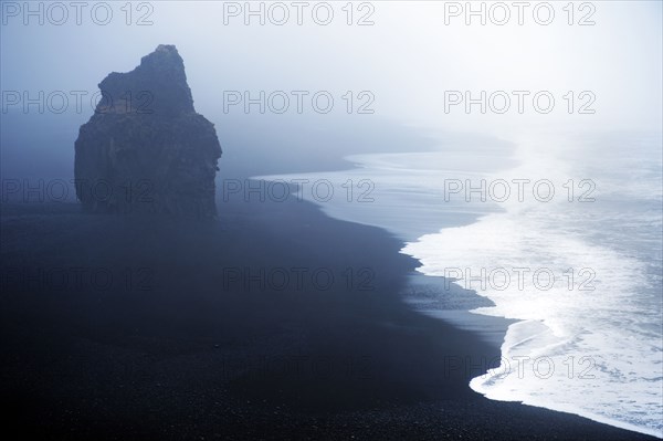 Waves washing up by rock formation on beach