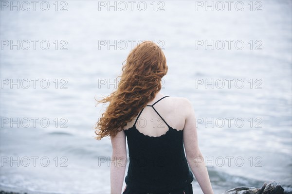 Rear view of girl sitting on beach