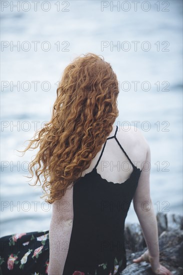 Rear view of girl sitting on beach