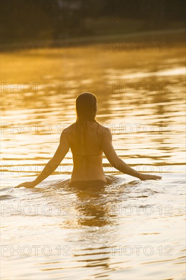 Asian woman standing in lake