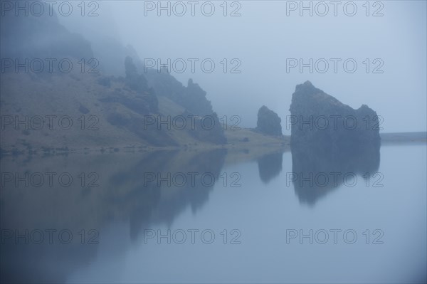 Rock formations and remote misty lake