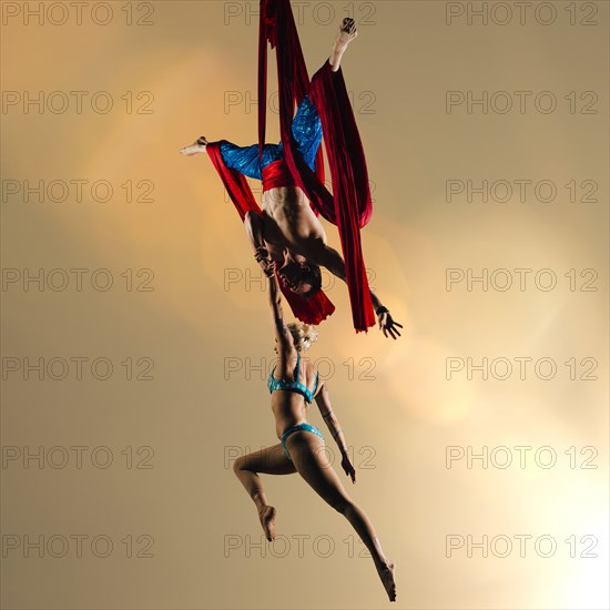 Caucasian acrobats performing with silk ropes