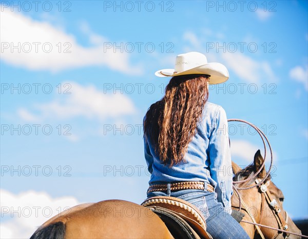 Caucasian cowgirl riding horse in rodeo outdoors