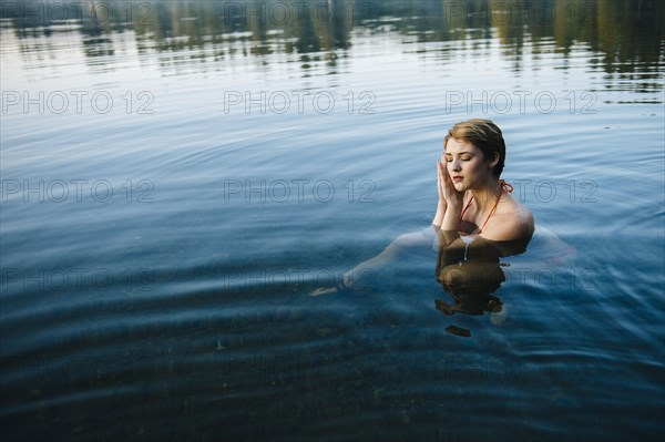 Caucasian woman sleeping in still lake