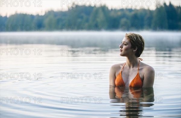 Caucasian woman swimming in still lake