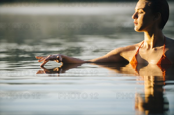 Caucasian woman swimming in still lake